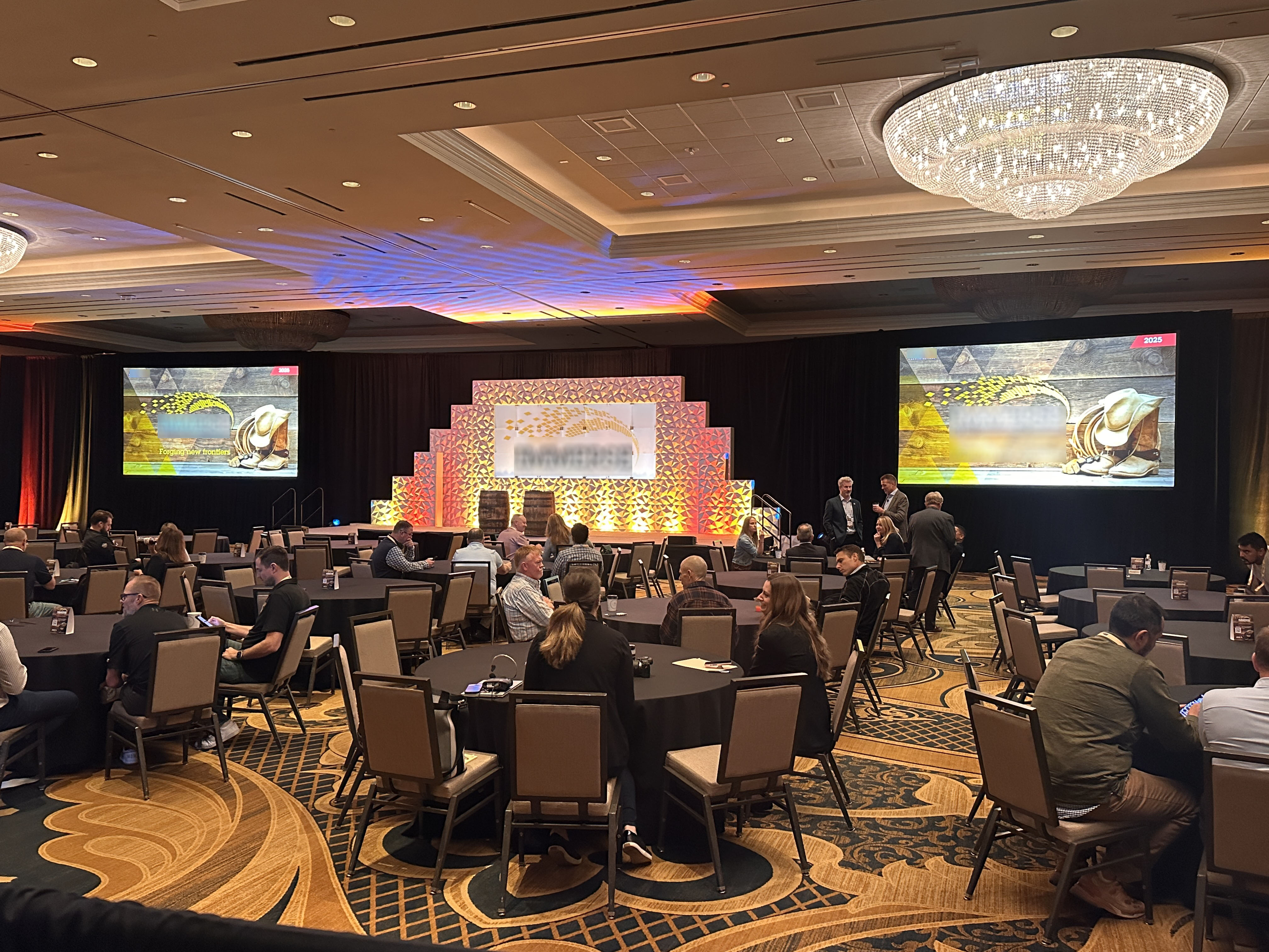 Conference ballroom with stage set, lighting and two large LED screens